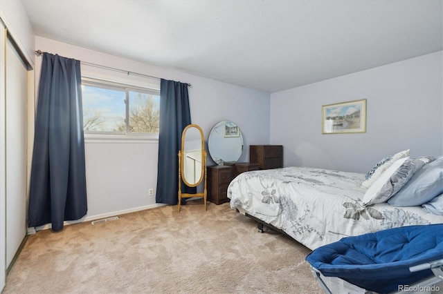 carpeted bedroom featuring visible vents and baseboards