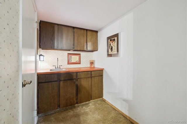 bar with light carpet, baseboards, and a sink