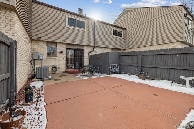 snow covered patio with fence and central air condition unit