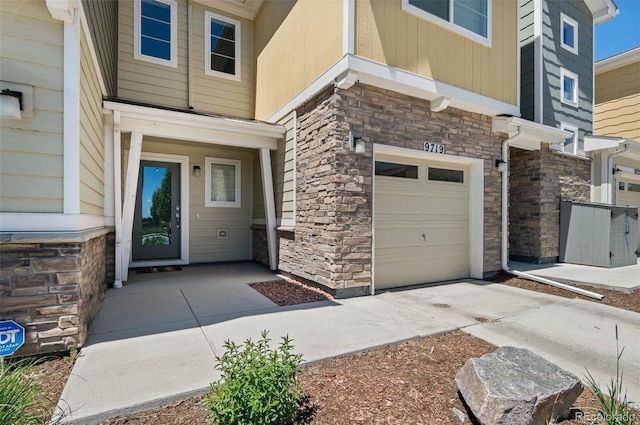 9719 Albion Ln, Thornton, CO 80229 - entrance to property featuring stone siding, a garage, and driveway