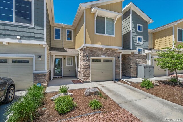 9719 Albion Ln, Thornton, CO 80229 - townhome / multi-family property with stone siding, a garage, and driveway