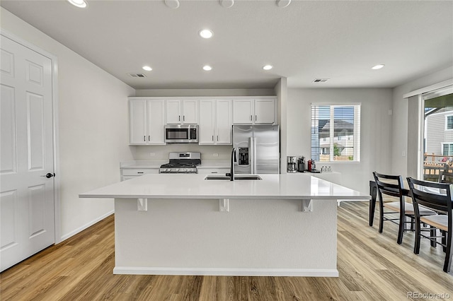 4644 Hatcher Dr, Brighton, CO 80601 - kitchen with appliances with stainless steel finishes, light countertops, recessed lighting, white cabinets, and a kitchen island with sink