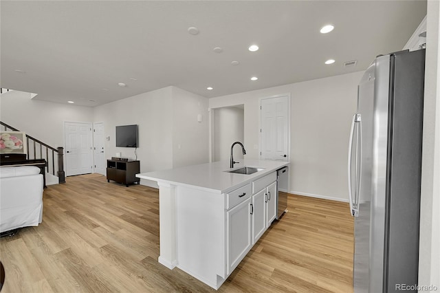 4644 Hatcher Dr, Brighton, CO 80601 - kitchen with appliances with stainless steel finishes, light wood-type flooring, open floor plan, a kitchen island with sink, and recessed lighting