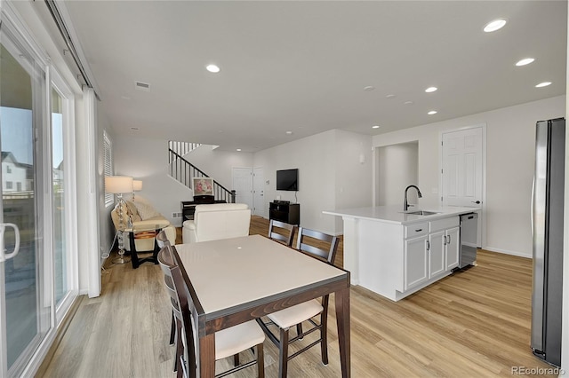 4644 Hatcher Dr, Brighton, CO 80601 - dining space with light wood-style flooring, stairs, and recessed lighting