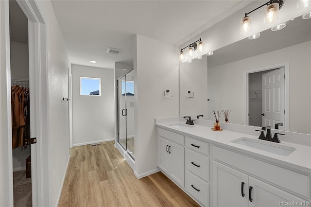 4644 Hatcher Dr, Brighton, CO 80601 - full bathroom with a walk in closet, double vanity, a shower stall, wood finished floors, and recessed lighting