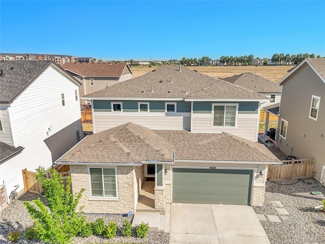 4644 Hatcher Dr, Brighton, CO 80601 - view of front of home with stone siding, a shingled roof, concrete driveway, and an attached garage