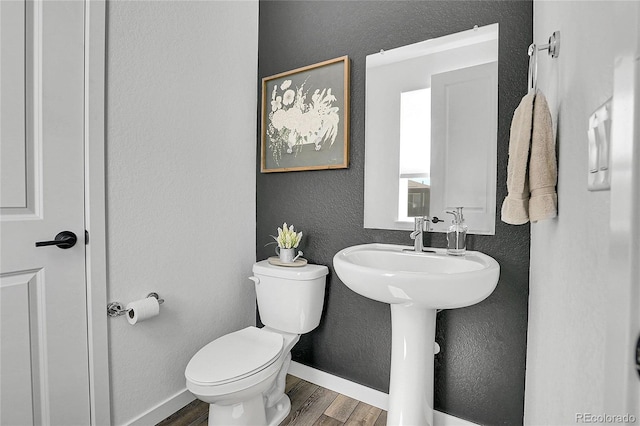8728 Hotchkiss St, Littleton, CO 80125 - half bath with wood finished floors, toilet, a textured wall, and baseboards