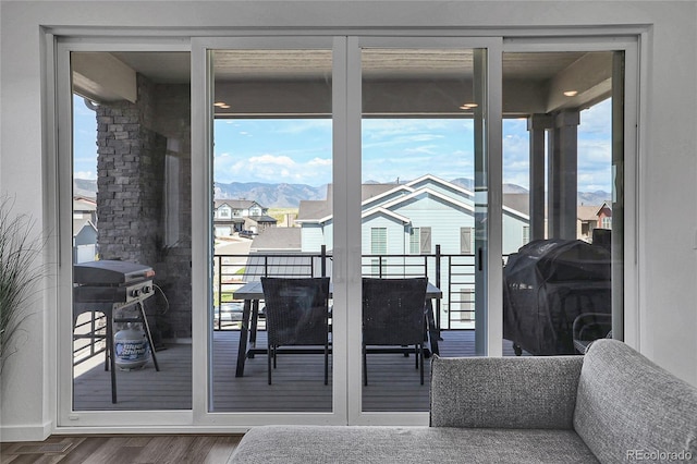 8728 Hotchkiss St, Littleton, CO 80125 - doorway to outside featuring wood finished floors, healthy amount of natural light, a mountain view, and a residential view