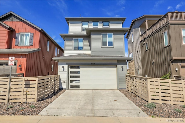 8728 Hotchkiss St, Littleton, CO 80125 - view of front of house with fence, an attached garage, and driveway