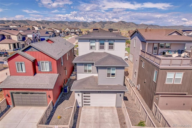 8728 Hotchkiss St, Littleton, CO 80125 - view of front of home with a residential view, concrete driveway, an attached garage, a mountain view, and fence