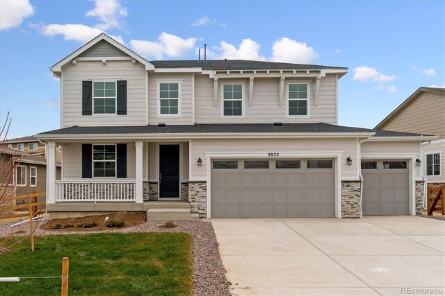 view of front of house with a front yard, a porch, and a garage