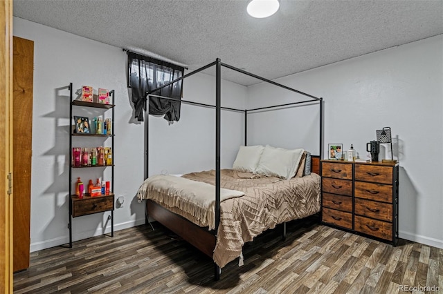 bedroom featuring dark hardwood / wood-style floors and a textured ceiling