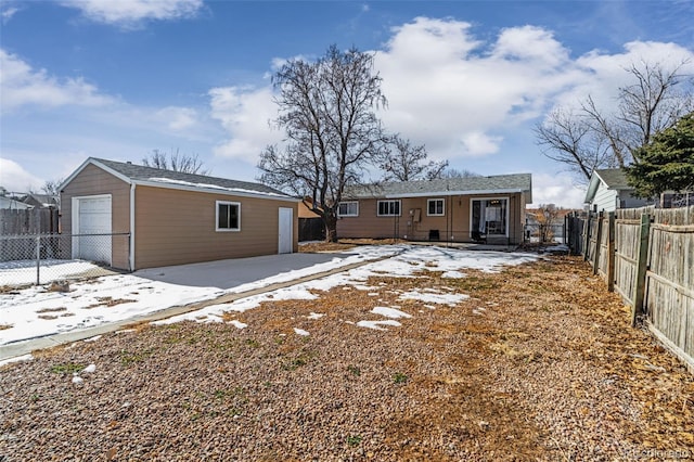 rear view of house featuring a garage and an outdoor structure