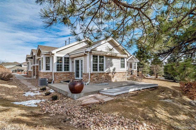 back of property with stone siding and cooling unit