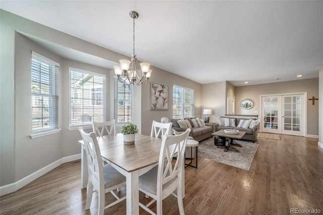 dining area featuring recessed lighting, baseboards, light wood finished floors, and an inviting chandelier