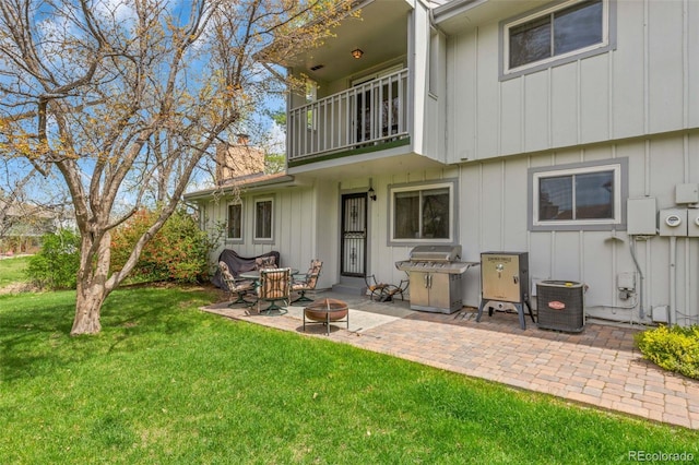 387 Upham St, Lakewood, CO 80226 - back of house with a balcony, board and batten siding, an outdoor fire pit, a patio area, and a yard