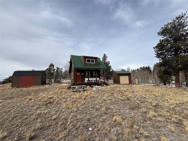 view of front of home with a garage and a shed