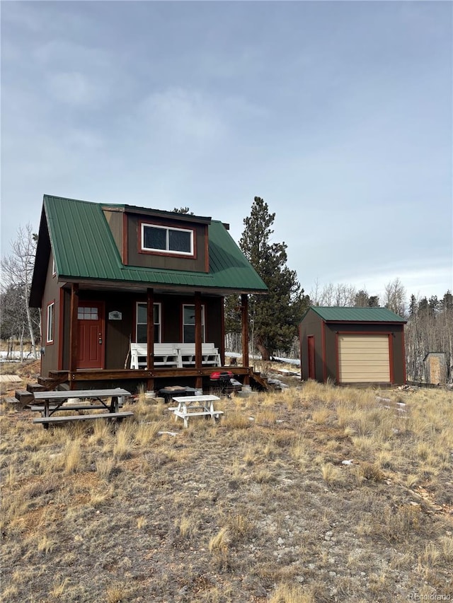 view of front facade featuring a porch, a garage, and an outdoor structure