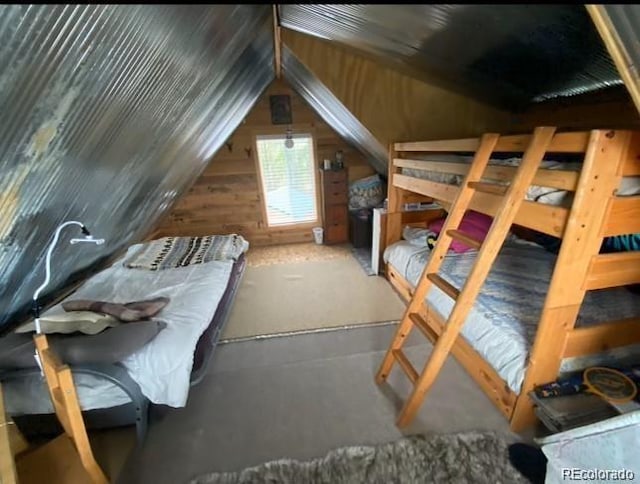 bedroom with vaulted ceiling and wood walls