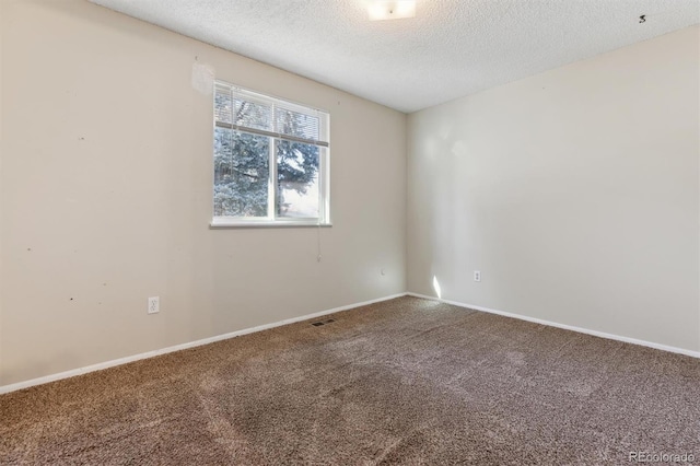 unfurnished room featuring carpet and a textured ceiling