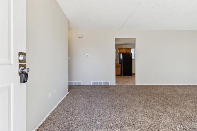 carpeted empty room featuring a textured ceiling