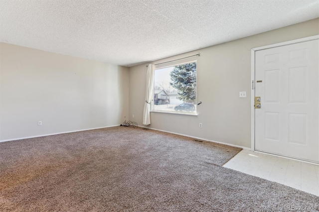 foyer with a textured ceiling and carpet floors