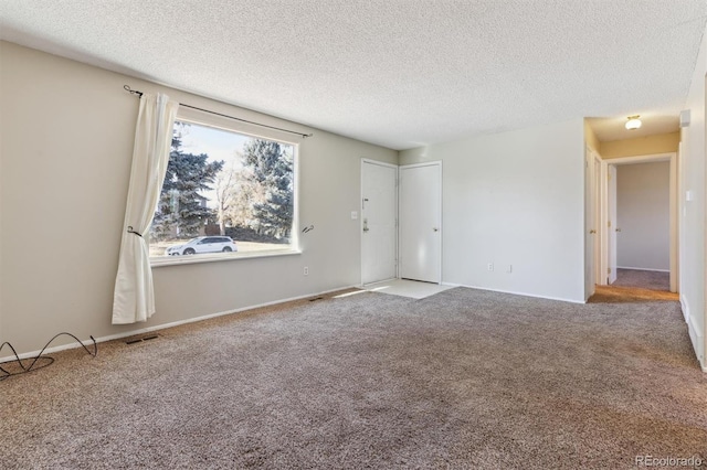 spare room featuring carpet floors and a textured ceiling