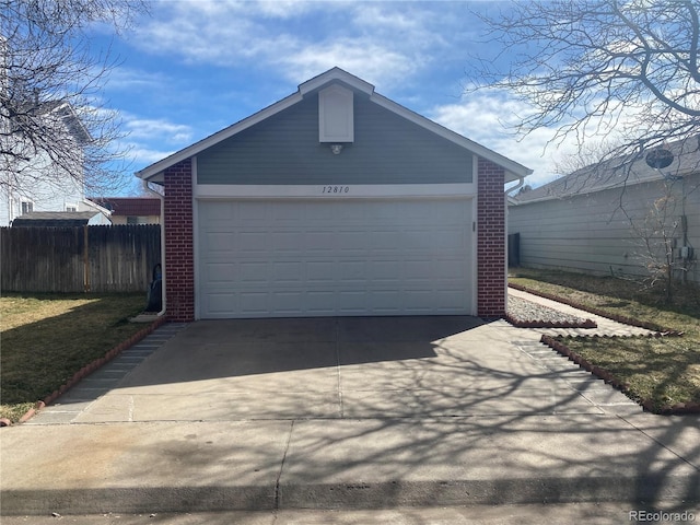garage featuring driveway and fence