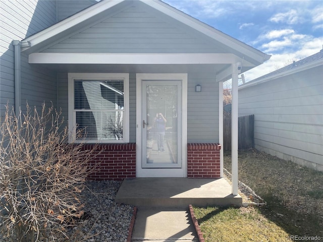 doorway to property featuring brick siding