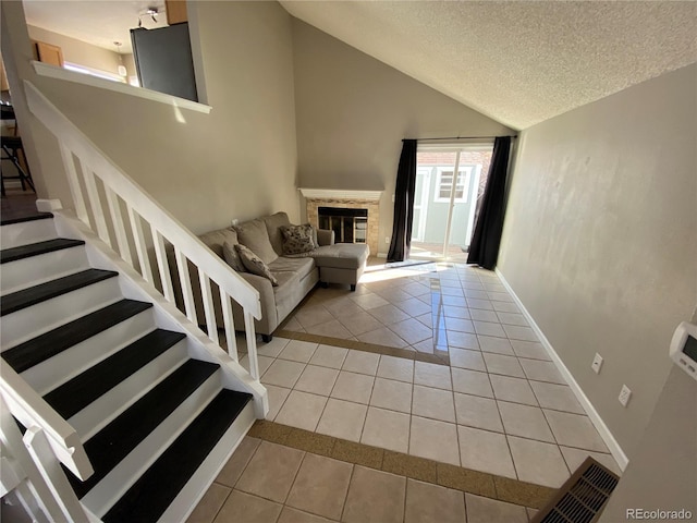unfurnished living room with light tile patterned flooring, stairs, a textured ceiling, baseboards, and visible vents