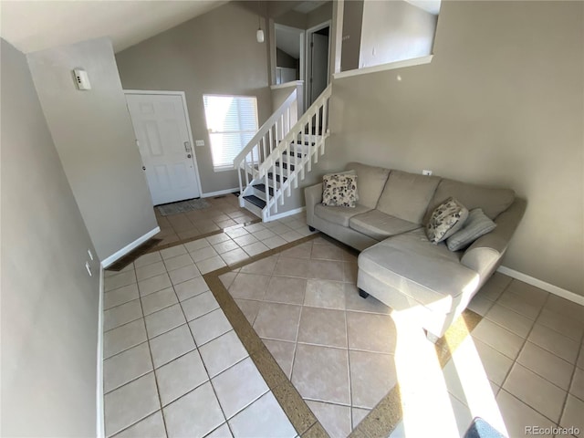 unfurnished living room featuring baseboards, stairway, high vaulted ceiling, and tile patterned flooring