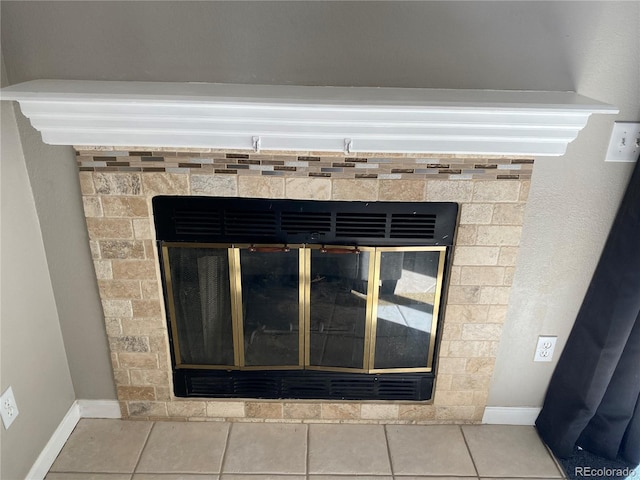 interior details featuring baseboards and a glass covered fireplace