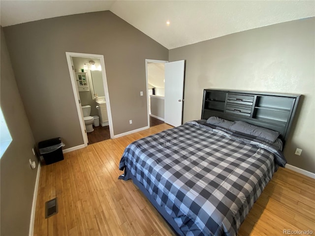 bedroom with light wood-style flooring, visible vents, baseboards, connected bathroom, and vaulted ceiling
