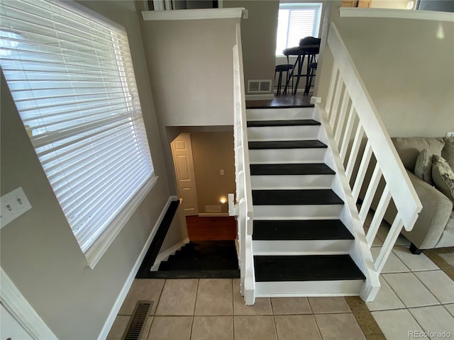 stairway featuring visible vents and tile patterned flooring