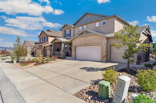 craftsman inspired home with stucco siding, driveway, board and batten siding, a garage, and stone siding