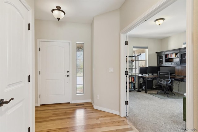 foyer with wood finished floors and baseboards