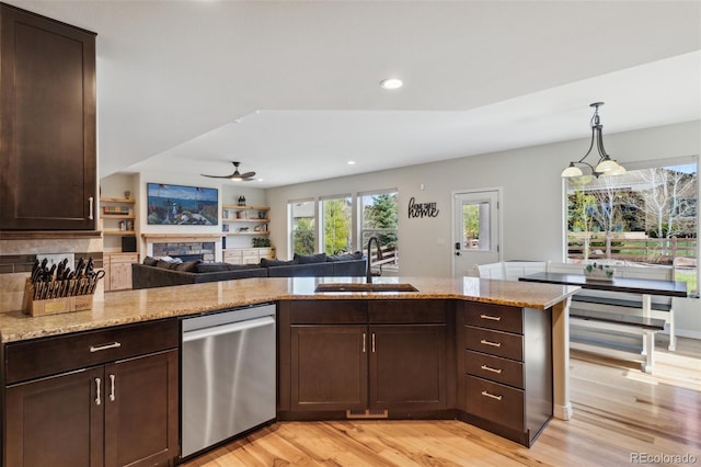 kitchen featuring dishwasher, a sink, light wood-style flooring, dark brown cabinetry, and light stone counters