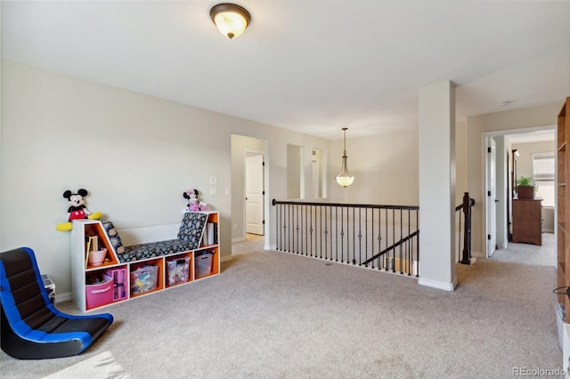 sitting room featuring an upstairs landing, carpet flooring, and baseboards