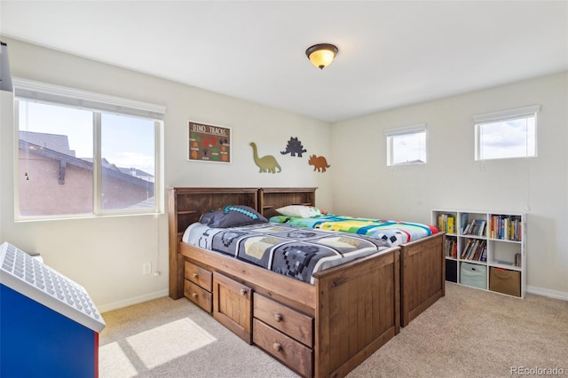 bedroom with light carpet and baseboards