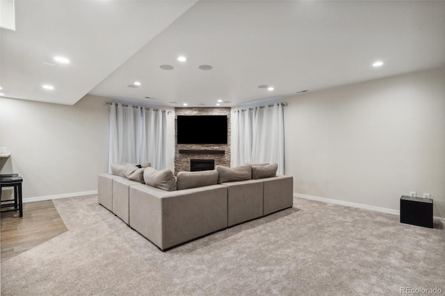 carpeted living area featuring a fireplace, recessed lighting, and baseboards