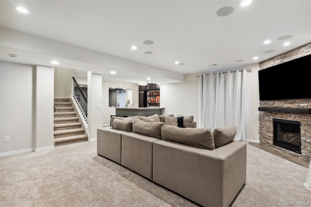 living room featuring carpet flooring, a bar, stairway, a stone fireplace, and recessed lighting