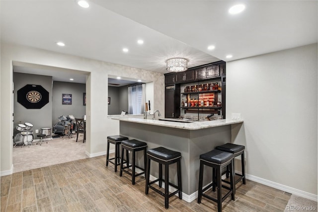 indoor wet bar with light wood-style floors, baseboards, and recessed lighting