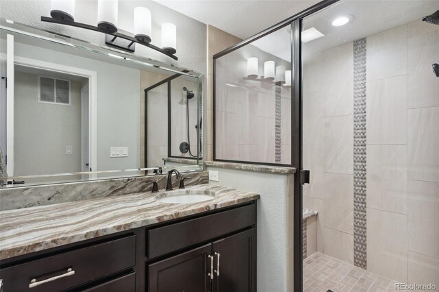 full bathroom with a shower stall and vanity