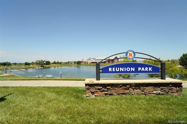 view of home's community with a water view and a lawn