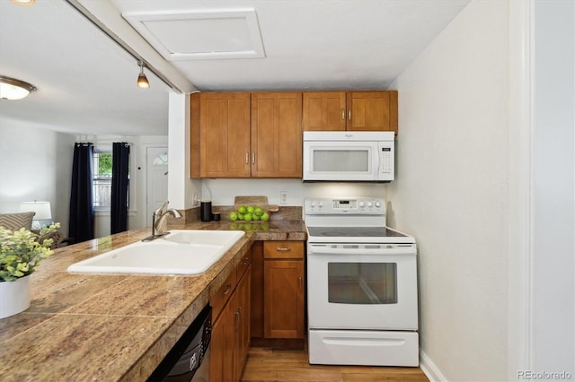 kitchen with white appliances, a sink, tile countertops, and brown cabinetry
