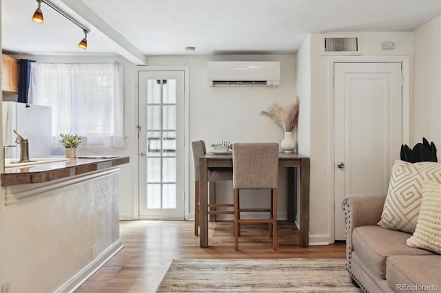 1532 N High St Unit 1, Denver, CO 80218 - living area featuring a wall mounted air conditioner, light wood finished floors, and healthy amount of natural light