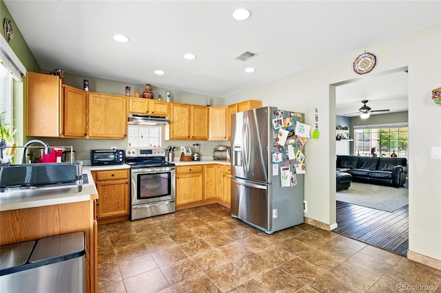 5552 Odessa St, Denver, CO 80249 - kitchen featuring stainless steel appliances, under cabinet range hood, light countertops, baseboards, and a ceiling fan