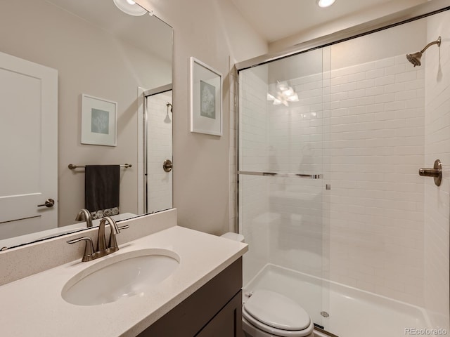 bathroom with vanity, a stall shower, and toilet