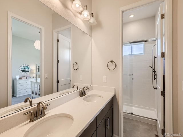 full bath with a sink, a shower stall, toilet, and double vanity