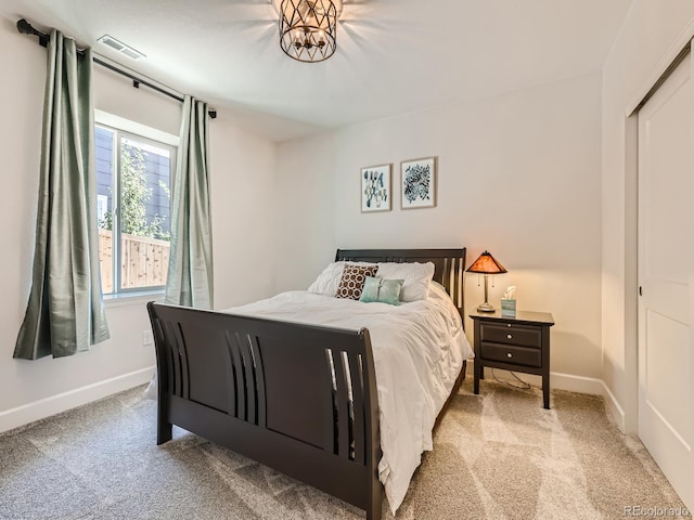 bedroom featuring visible vents, baseboards, and light carpet